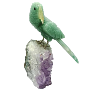 Image : perroquet avec le corps en aventurine (vert), bec en quartz (blanc), griffes en laiton (jaune) et perché sur un bloc d'améthyste (violet) cristallisée (vue de face).